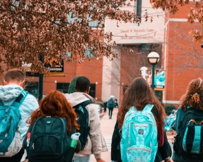 Group of college students walking on campus with backpacks
