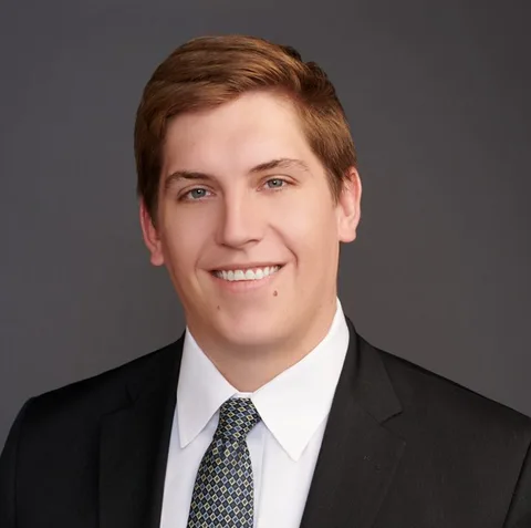 Brendon Dashiell in a suit and tie, smiling against a plain background.