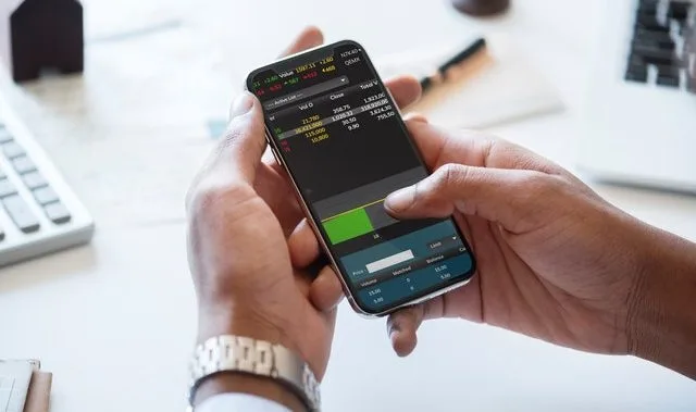 Person trading stocks on their phone