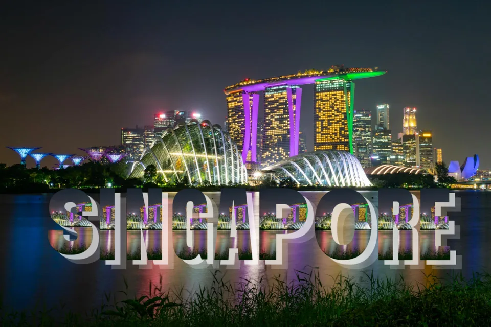 Night view of Singapore's skyline with illuminated landmarks and "Singapore" text overlay.