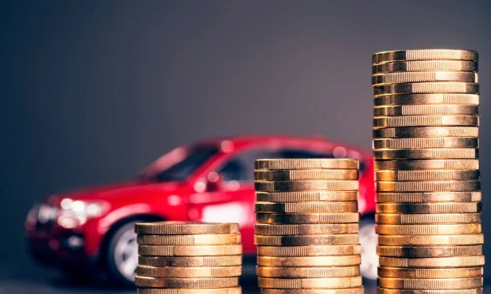 A car parked behind a series of increasingly high coin piles