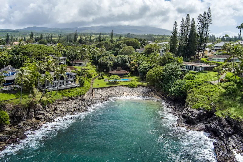A small bay, crescent shaped and cobble stone beach at Alaeloa. The heated pool and club house is located above the pool. 