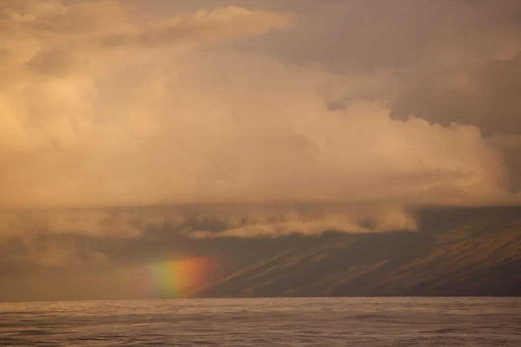 Maui Real Estate Market Update Q4 2023 Vol. 2 2 A rainbow along the base of the West Maui coastline as seen from offshore.