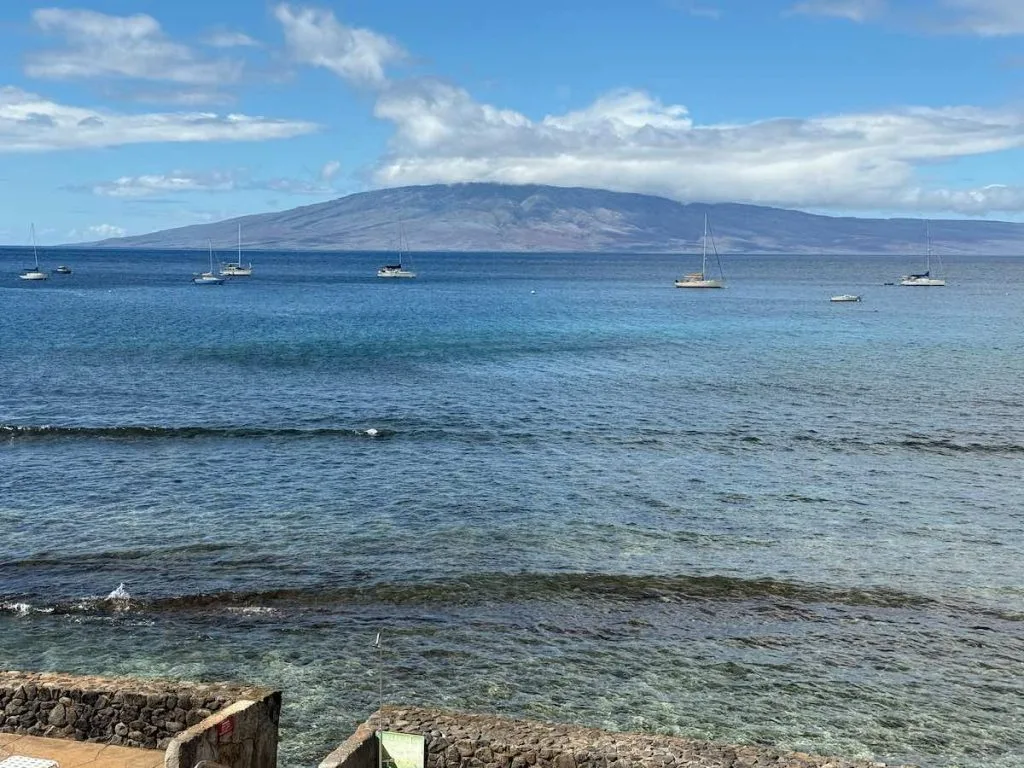 Lahaina Roads Condos for Sale 1 One of the biggest appeals of a Lahaina Roads Condos for Sale is the view. This photo shows a view from the lanai of one of the condos with sailboats moored offshore, clear waters teeming with sea turtles and the neighboring island of Lanai in the distance.