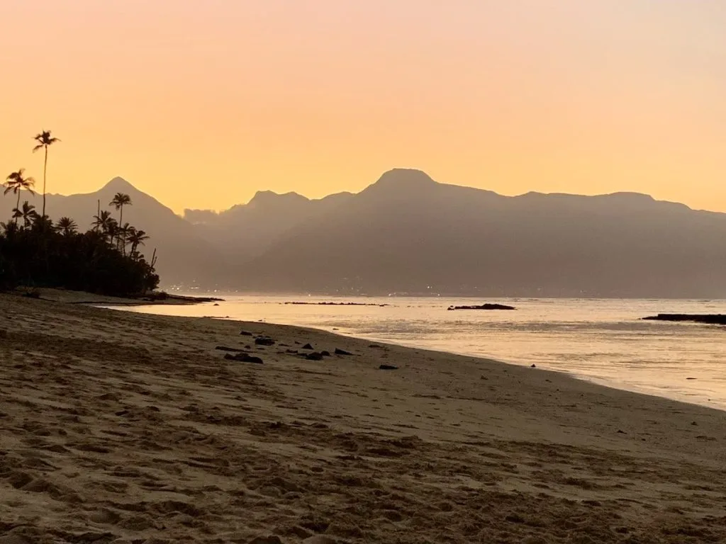 The August 2025 Maui Statistics and Market Update Maui Beauty Photo features sunset afterglow over the West Maui Mountains taken from Baldwin Beach