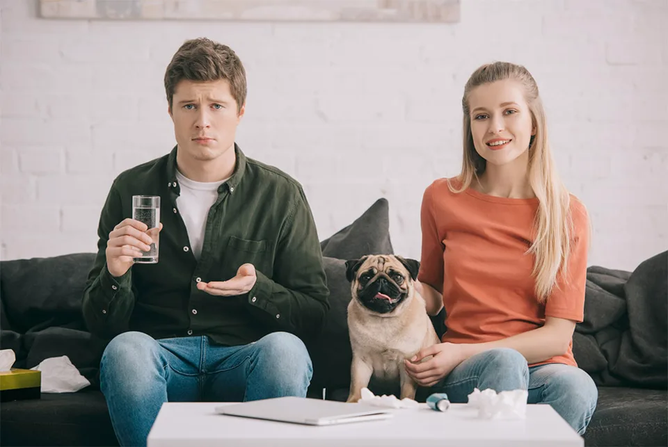 Ways to prepare “Non-Animal Loving” Houseguests 7 annoyed guy on couch next to dog