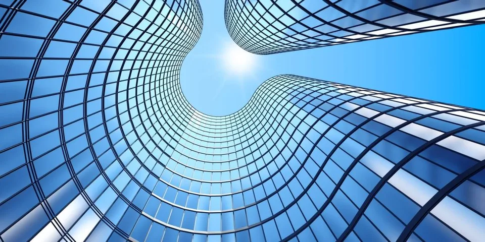 Glass of skyscrapers viewed from below with the bright sun shining above