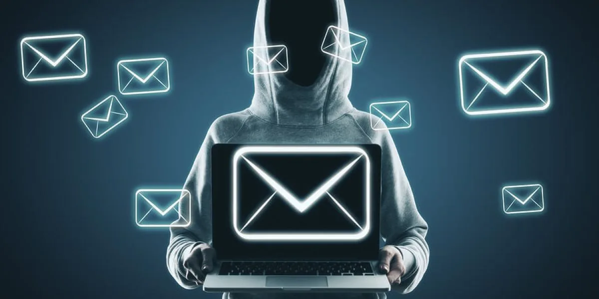 Person in a hoodie holding a laptop displaying an email icon, surrounded by floating email graphics.