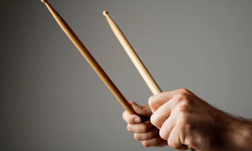 a man holding drumsticks while learning how to play drums
