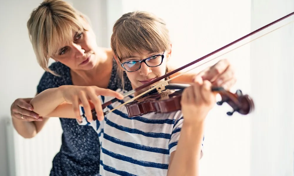 Teacher teaching student beginning violin