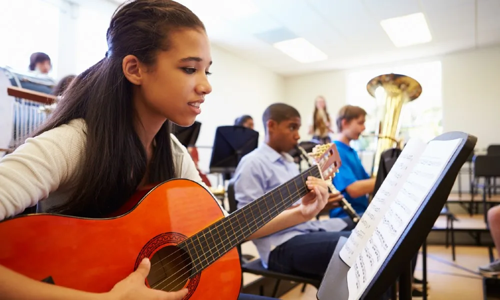 Girl playing guitar, showing her musical intelligence