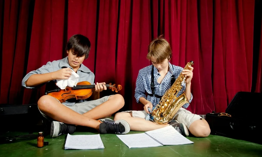 Your Guide to Musical Instrument Cleaning and Maintenance 3 music students cleaning their instruments