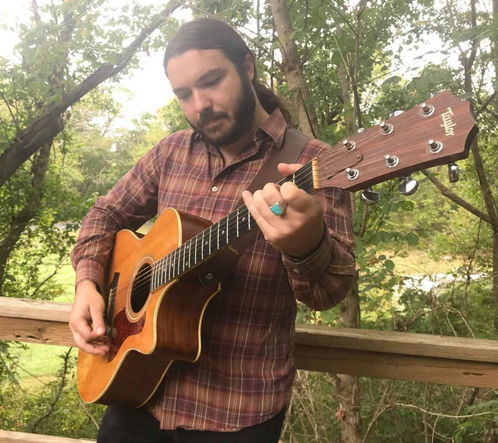 derek kretzer playing guitar outside in nature