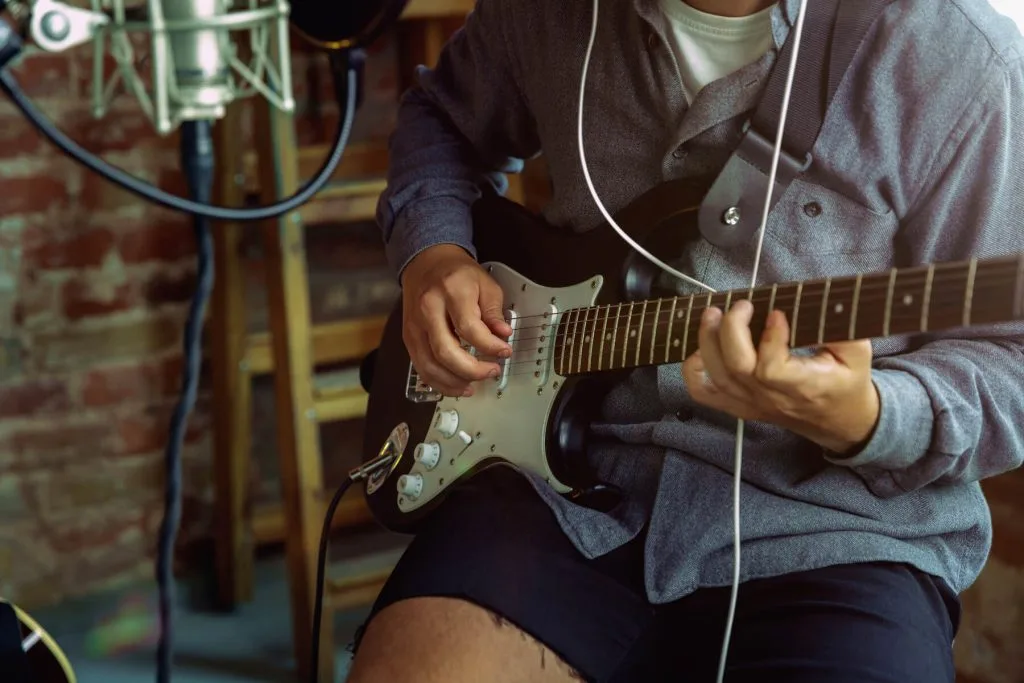 artist playing the bass guitar and recording