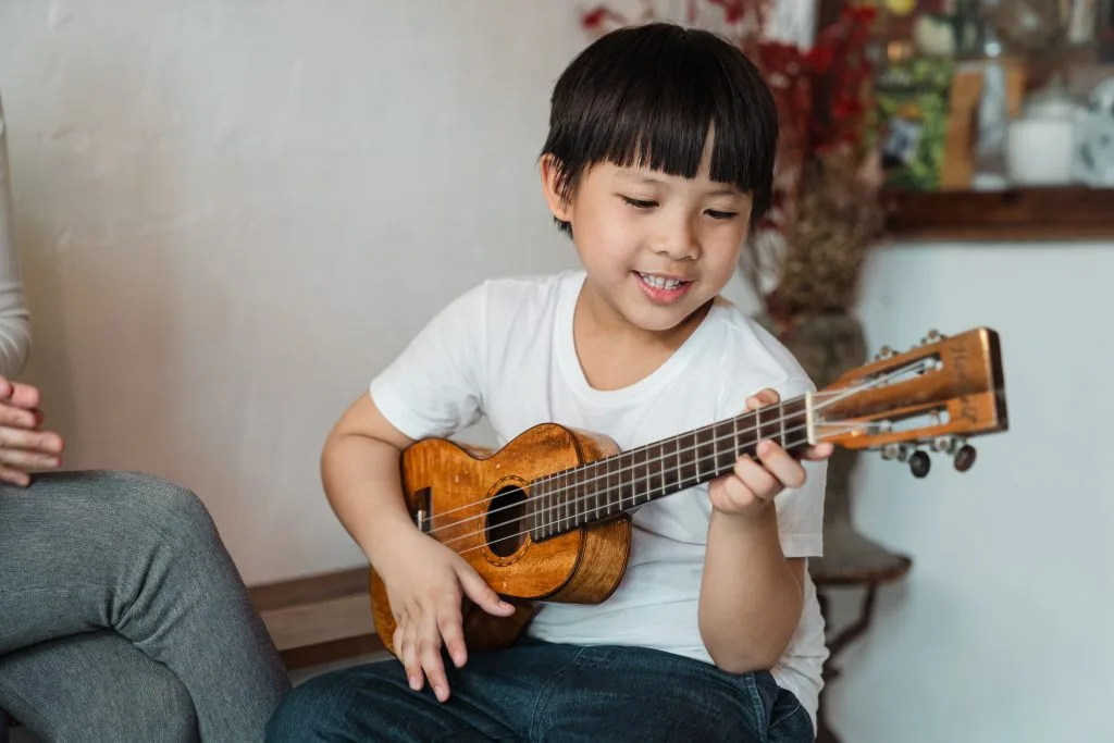 7 Reasons Why Performing Music Leads to Academic Success for Children 9 boy performing music ukulele