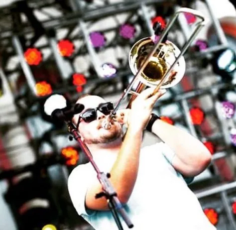 kris nigh playing trombone on stage headshot